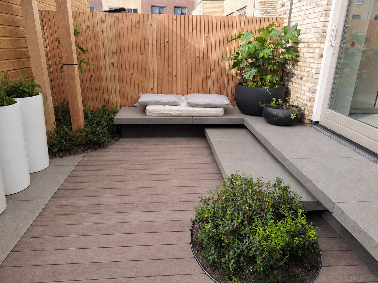 Kleine stadstuin Spijkenisse Dijkman Hoveniers Kleine moderne stadstuin in Spijkenisse met vlonder, zitbank, bestrating en groene beplanting